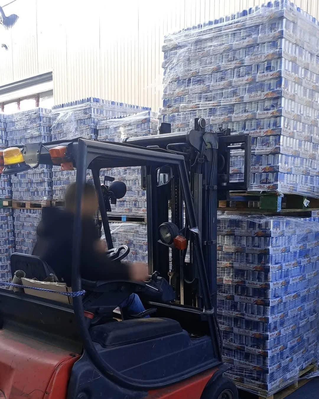 Forklift loading truckload energy drink order at warehouse dock